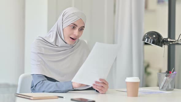 Young Arab Woman Celebrating Success on Reading Documents