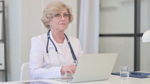 Old Female Doctor with Laptop Showing No Sign By Finger