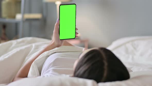 Latin Woman in Bed Using Smartphone with Green Screen, Chroma Screen 