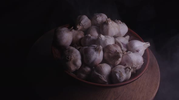 Pile of Whole Bulbs of Garlic in Ceramic Bowl on Table