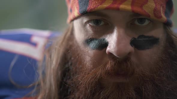 Close Up Portrait of a Bearded American Football Player with Long Hair and Beard in Sports Equipment