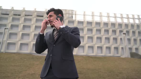 Businessman talking on the phone and walking