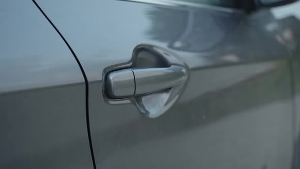 Closeup of Car Door Handle Opened By Man's Hand