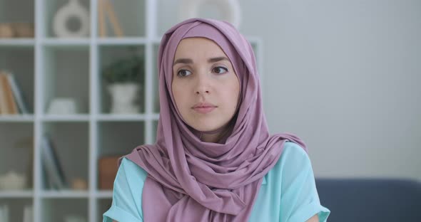 A Woman in a Hijab Looks Into the Camera and Silently Nods Her Head and Listens. Conversation