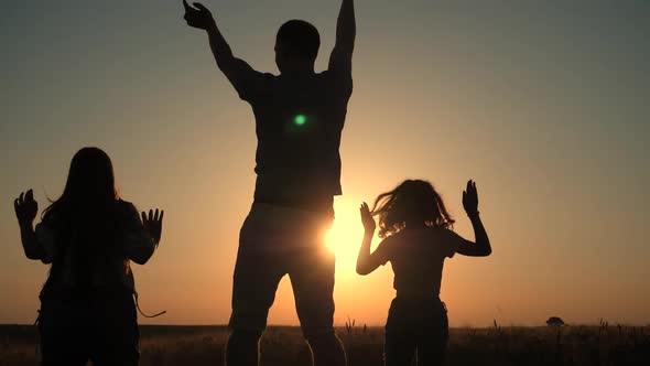 Happy family: father, and two daughter on nature on sunset