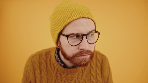 Young Adult Caucasian Guy in a Beanie Suspiciously Looking Around and Shushing Camera By Putting