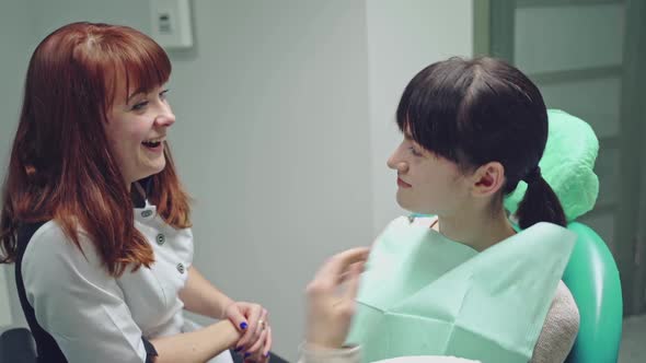 A young woman is sitting on a chair in the dental office on the consultation.