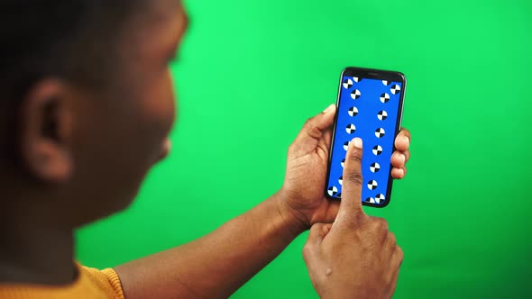 Black Man is Scrolling Pages on Smartphone with Tracking Markers Display and Green Screen