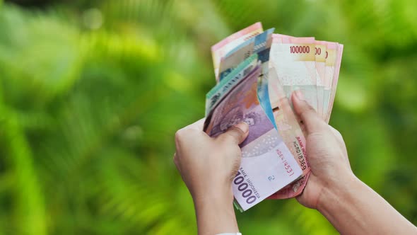 The Girl Recounts in the Hands of Indonesian Money