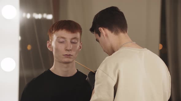 An Eyebrow Master Working with Brows of His Male Client  View From the Mirror