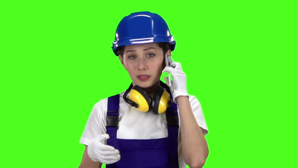 Builder Girl Is Standing and Talking on the Phone. Green Screen. Slow Motion alt
