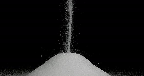 White Sugar falling against Black Background, Slow Motion 4K