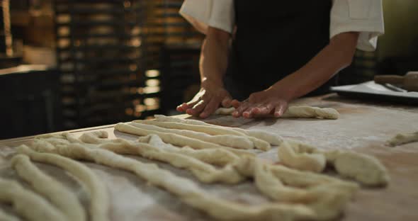 Animation of hands of african american male baker rolling sourdough at bakery