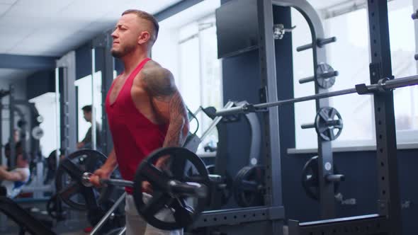 Male Athlete Doing Barbell Curl Exercise in a Gym