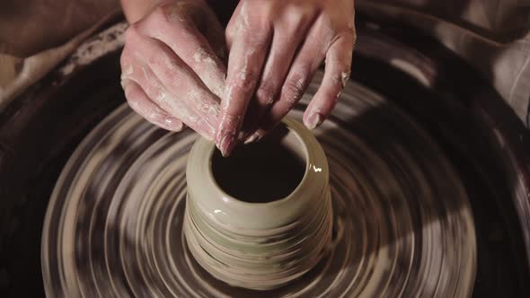 Young Woman Potter Shaping Wet Clay with Her Fingers