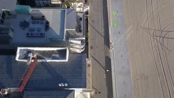 Slow motion beach houses at Santa Monica Pier.Dramatic aerial view flight bird's eye view tilt up d