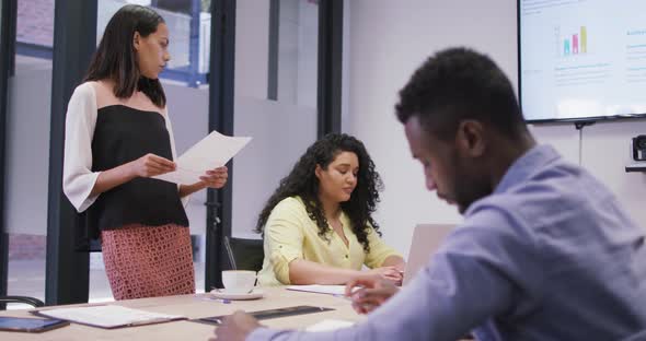 Diverse group of business people working together, discussing work in modern office