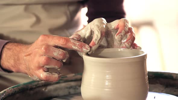 Mid section of potter making pot