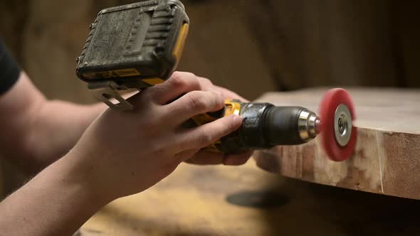 A master in personal protective equipment processes the end of a wooden blank