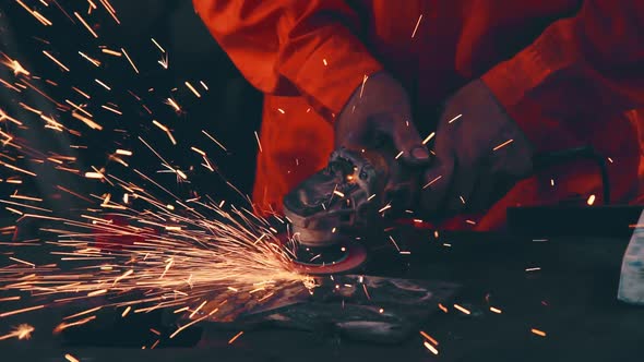 Professional mechanic is cutting steel metal.