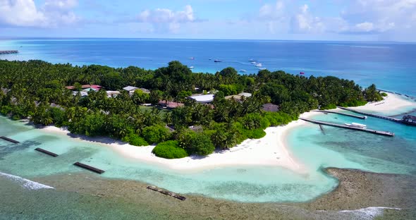 Wide aerial clean view of a white sandy paradise beach and blue sea background in colorful 4K