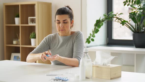 Woman Applying Hand Sanitizer at Home