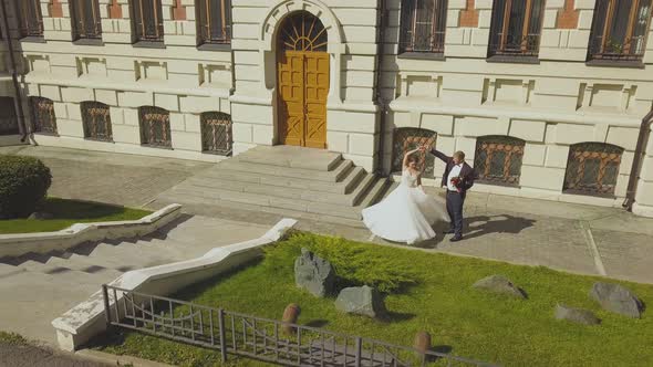 Newly Wedded Couple Dances at Modern Building Upper View