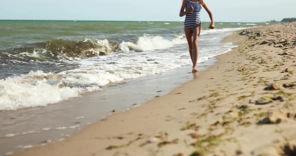 Happy, joyful little girl run on the beach, sea family vacation