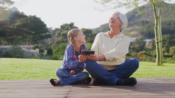 Happy grandmother and little girl sitting and using tablet 4K 4k