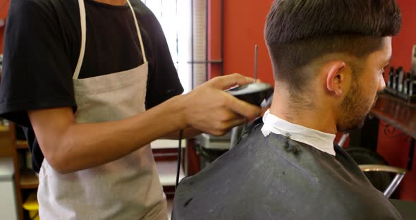 Man getting his hair trimmed with trimmer 