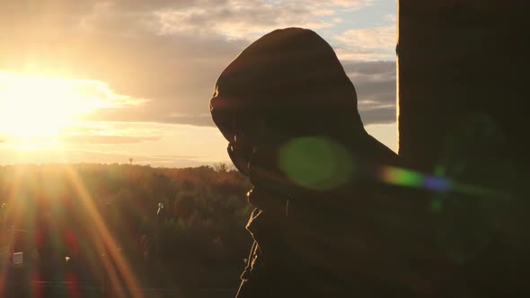 Unrecognizable Bearded Man Puts on Yellow Hood Over Gas Mask Sun Shines Into Camera Beautiful