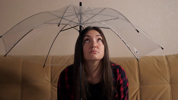 Pensive Woman Hides From Flowing Water Under Clear Umbrella