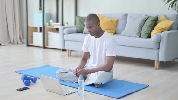 African Man Doing Video Call on Laptop While on Yoga Mat