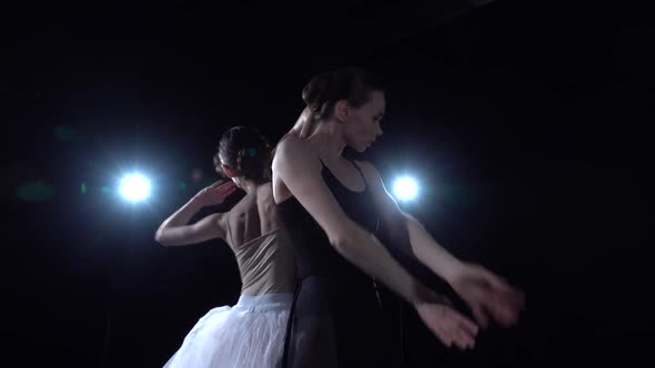 Two Ballerinas in White and Black Tutu Spinning in Dance