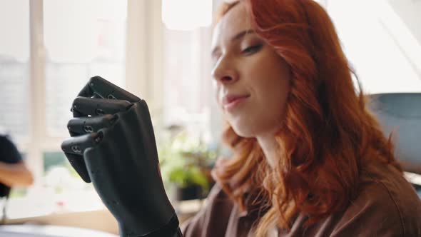 Portrait of a Young Attractive Girl Operating Her Robotic Prosthesis Flexing and Extending Her