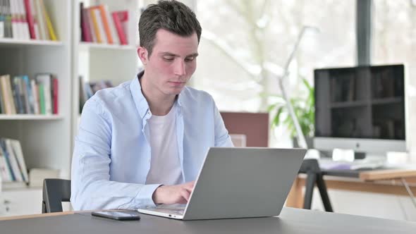 Busy Young Man Working on Laptop