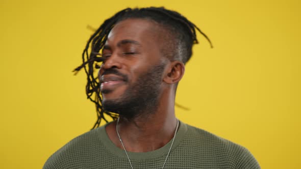 Headshot of Cheerful African American Handsome Man Shaking Dreadlocks on Head Smiling Looking at