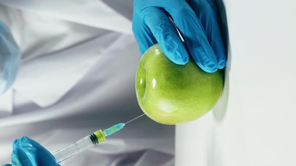 Vertical Video of Medical Scientist Inspecting Apple Working in Laboratory