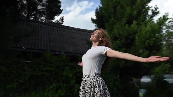 Happy Caucasian Woman Spread Her Arms to the Sides Outdoors