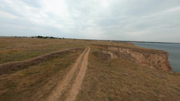 FPV Flight Over a Coastal Cliff at Cloudy Day