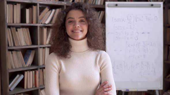 Confident Smiling Hispanic Woman Teacher Looking at Camera in Classroom