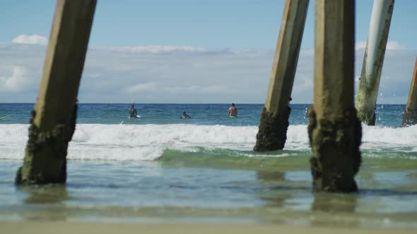 Surfers Relaxing Near a Pier