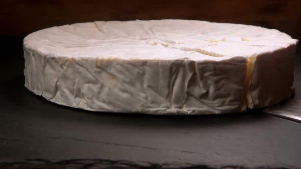Sector of Soft Brie Cheese Is Taken with a Knife