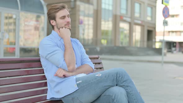 Tired Man Sleeping While Sitting Outdoor on Bench