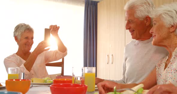 Senior couple being photographed by a friend