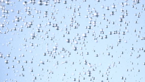 Super Slow Motion Shot of Moving Gel Bubbles in Water on Light Blue Background at 1000Fps