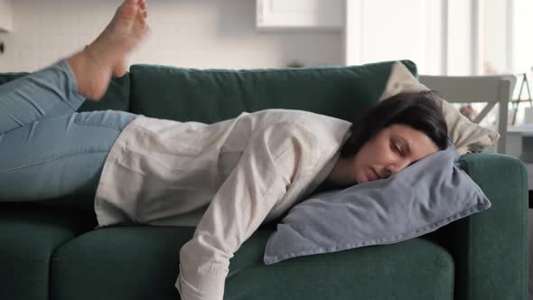 Tired Exhausted Brunette Woman Falls On Sofa With Pillow Cushions Falling Asleep