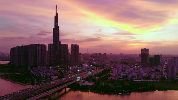 Cinematic vivid sky behind city skyline of Ho Chi Minh City; dusk aerial