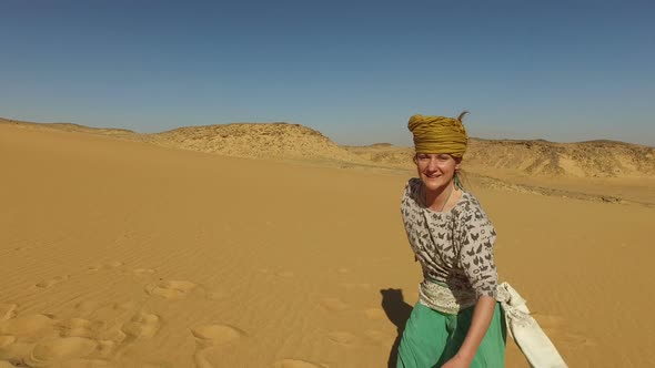 Happy woman dancing barefoot in desert, Egypt