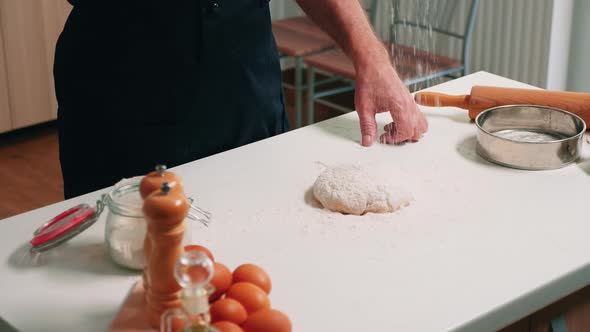 Baker Pouring Flour on Dough for Bread